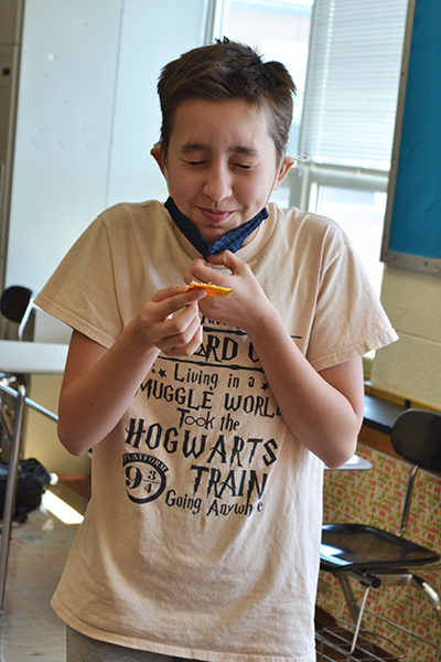 A Franklin STEAM Academy 7th grader who has just eaten an orange slice dipped in baking soda reacts to the fizz as a chemical reaction occurs in his mouth. 