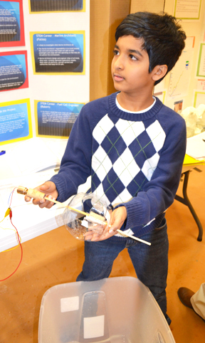 Next Gen sixth grader illustrates part of his team's hydropower design.