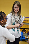 An Illinois researcher (center) interacts with an NGS student describing her science and engineering fair project.