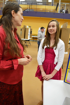 Science Fair coordinator Carrie Kouadio discusses Next Gen student's project with her.