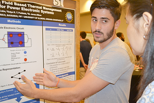 POETS REU participant Ian Rivera-Colon explains his study to a visitor at the Illinois Summer Research Symposium. 