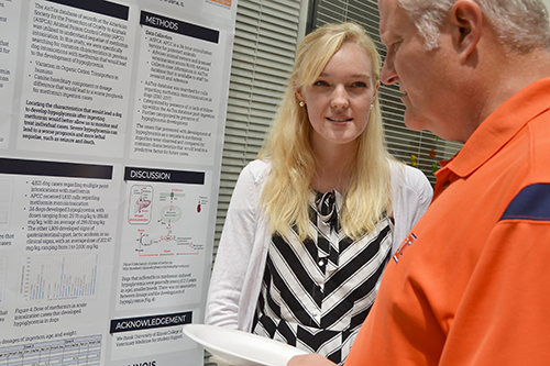 Jessica Kerr discusses her research with a visitor to  SRTP's end-of-summer poster session.