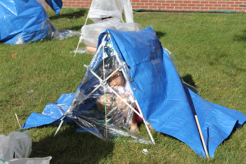  A student is hunkered down in her team’s tent, awaiting the monsoon test—being sprayed with a hose!