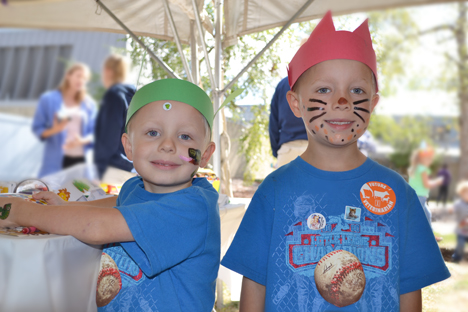 Two local boys display the headbands, facepaint, and tatoos they got at the Kids' Tent.