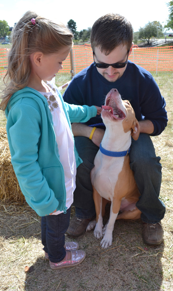 Vet Med student Josh Good and pit bull Kevin have a moment with a young visitor to the Open House.