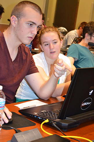 Two Blue Waters interns brainstorm during a coding session.