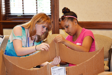 Two campers work during a hands-on project during which campers made solar ovens.