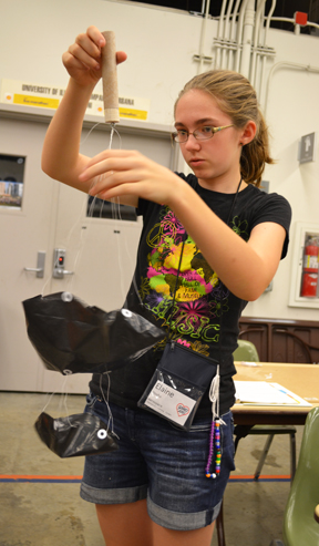 Aerospace GAMES camper tests the parachute she is making for her rocket.
